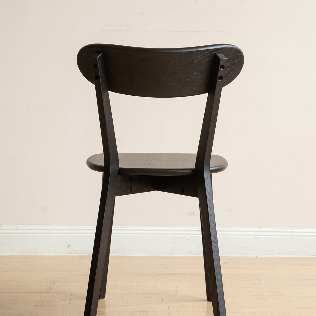 Back view of black Solid Oak Dining Chair showcasing its sturdy frame and smooth wood grain texture.