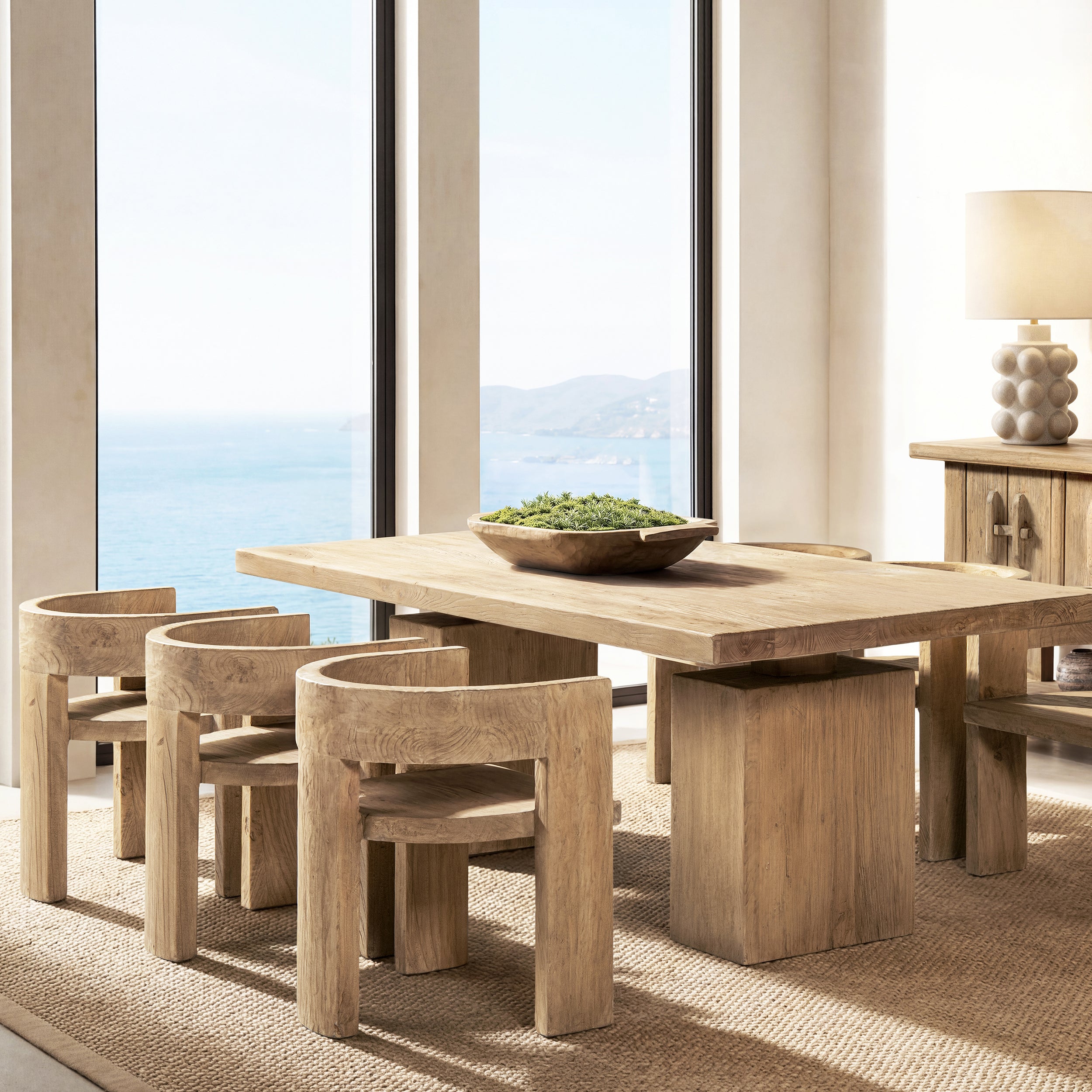Sculptural dining chair in light natural brown reclaimed elm, featuring a curved back and sturdy, modern wooden design.