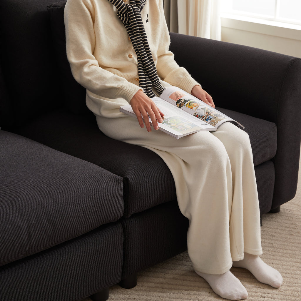 Person seated on modular sofa with ottoman, highlighting the plush seat cushions and cozy fabric texture.