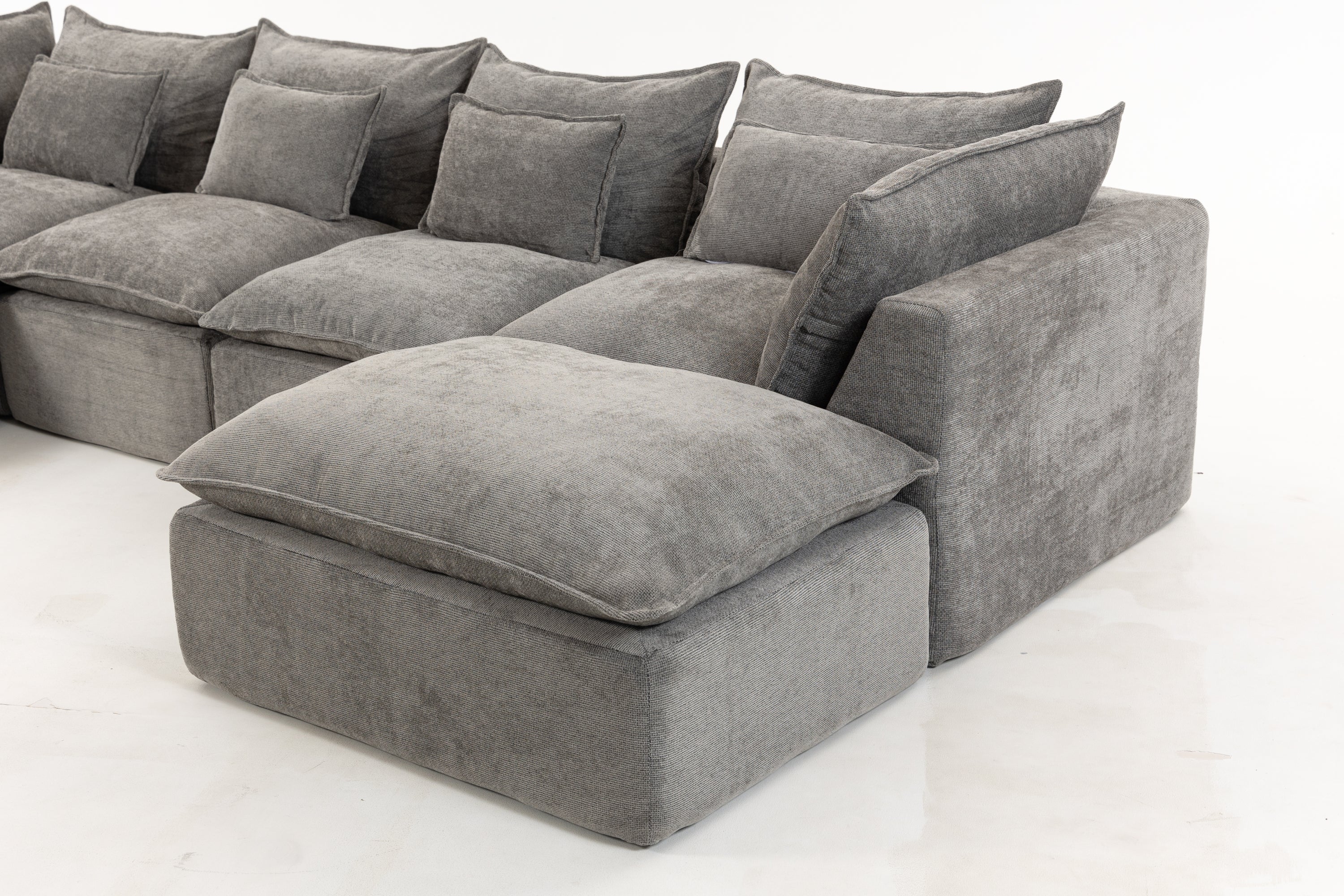 Close-up of right-side chaise on oversized modular sectional sofa in antique grey velvet with plush back and seat cushions.