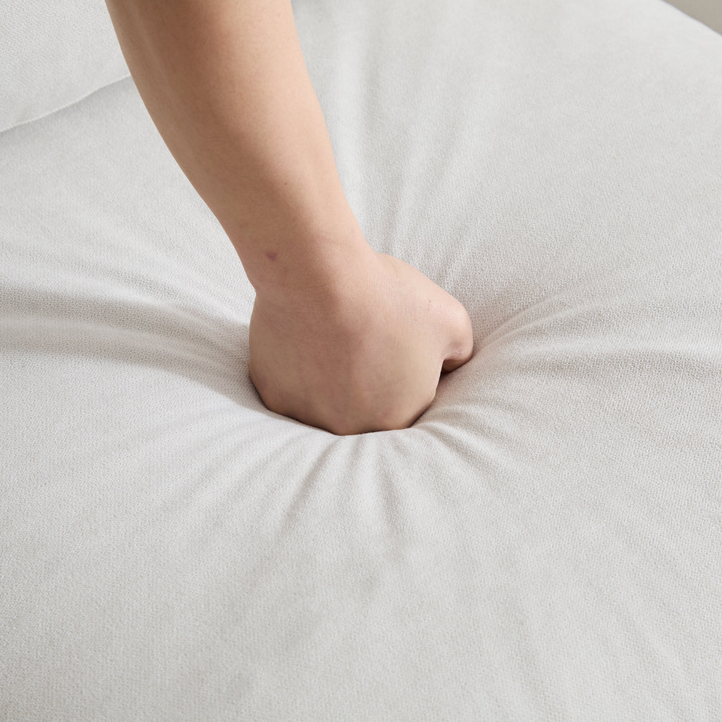 Hand pressing into the seat cushion of the 99 in. 4-piece L shaped modular sectional sofa, demonstrating its soft and supportive foam.