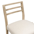 Close-up of ladder backrest and cushioned seat on counter stool. Features smooth wood finish and neutral fabric for versatile decor.