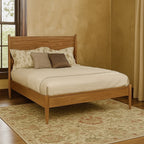 Full size Mid-Century Modern oak platform bed placed in a cozy bedroom with floral rug, showcasing its sleek wood frame and minimalist design.