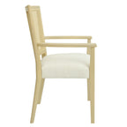 Side profile of modern dining chair with rattan back and padded seat, highlighting ergonomic armrests and sleek wood design.