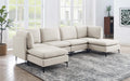 Beige linen modular sectional sofa with dual chaises and black metal legs in a bright, modern living room.