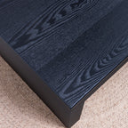 Detailed view of the black wood grain tabletop on the modern ribbed coffee table, showcasing its natural texture and finish.