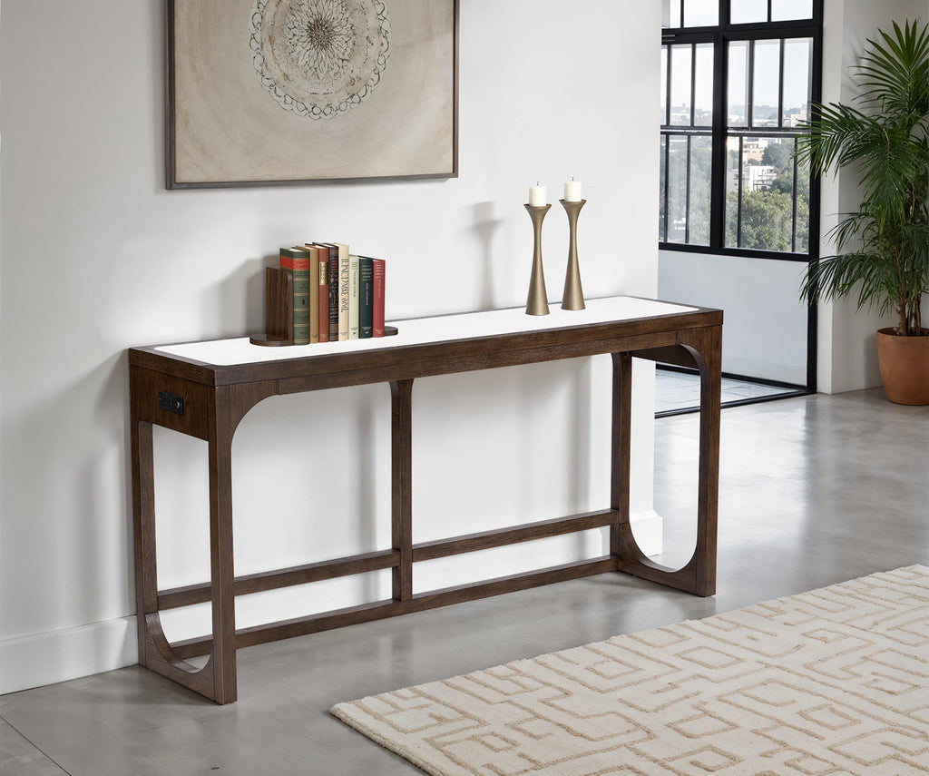 Transitional sofa table with USB port in dark walnut finish placed against a white wall in a modern living room. Features sleek engineered wood design.