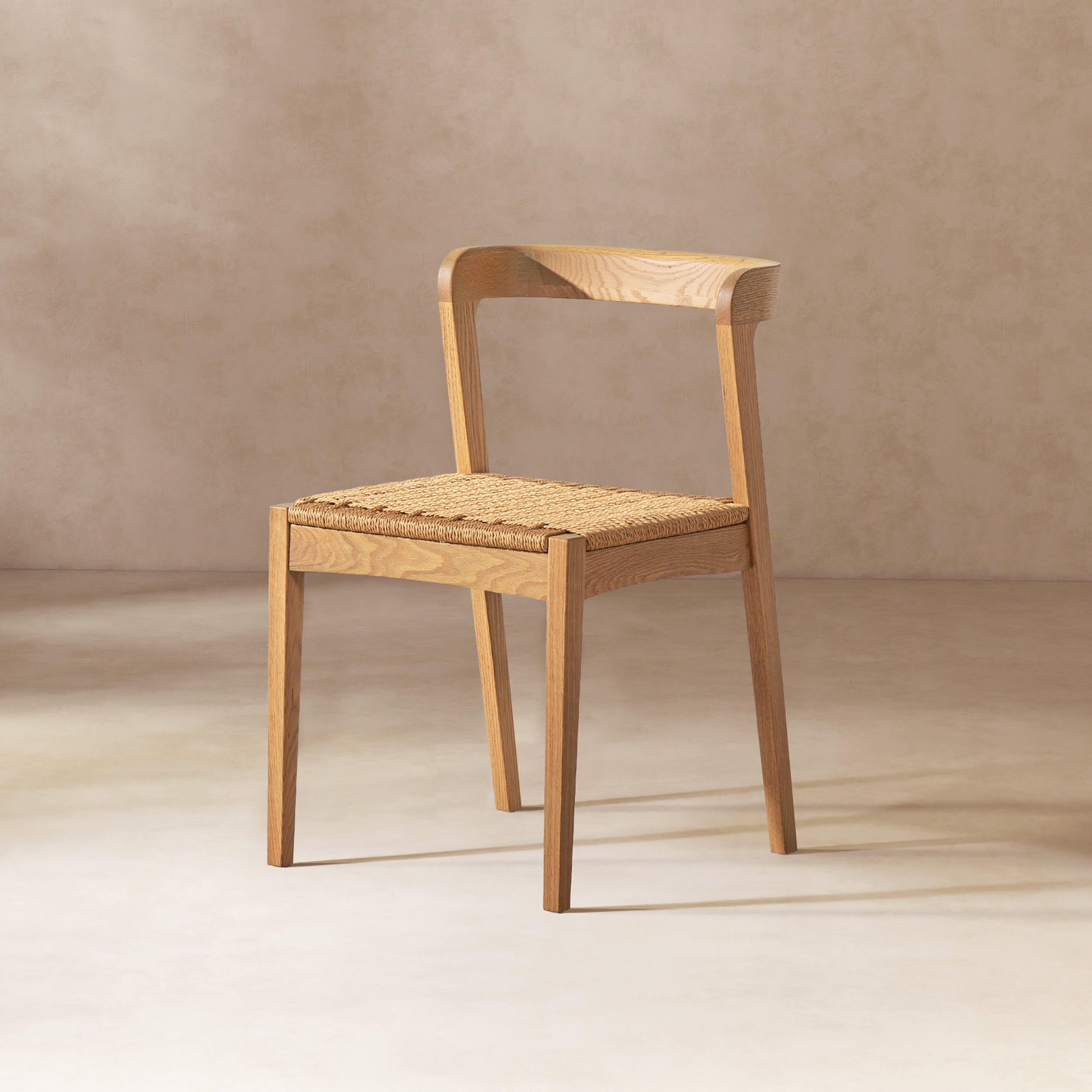 Single Capri Oak Wood Dining Chair with natural brown red oak finish and woven seat, displayed against a neutral background for product focus.