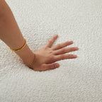 Hand pressing into the soft chenille fabric of the 109.4' modular sectional sofa, demonstrating its foam-filled comfort.
