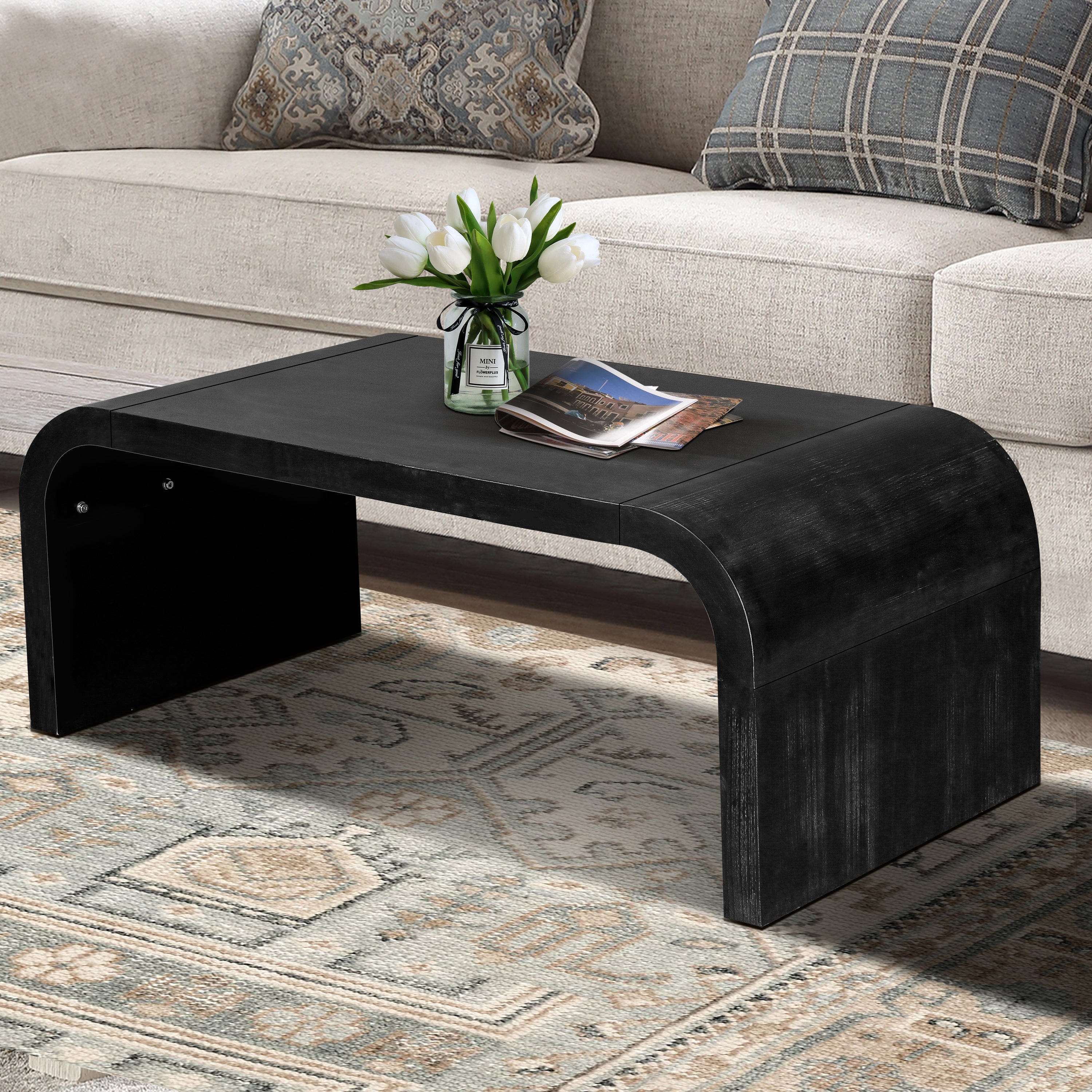 Vintage Farmhouse Coffee Table with curved edges and black wood grain finish, placed in a rustic living room with patterned rug.