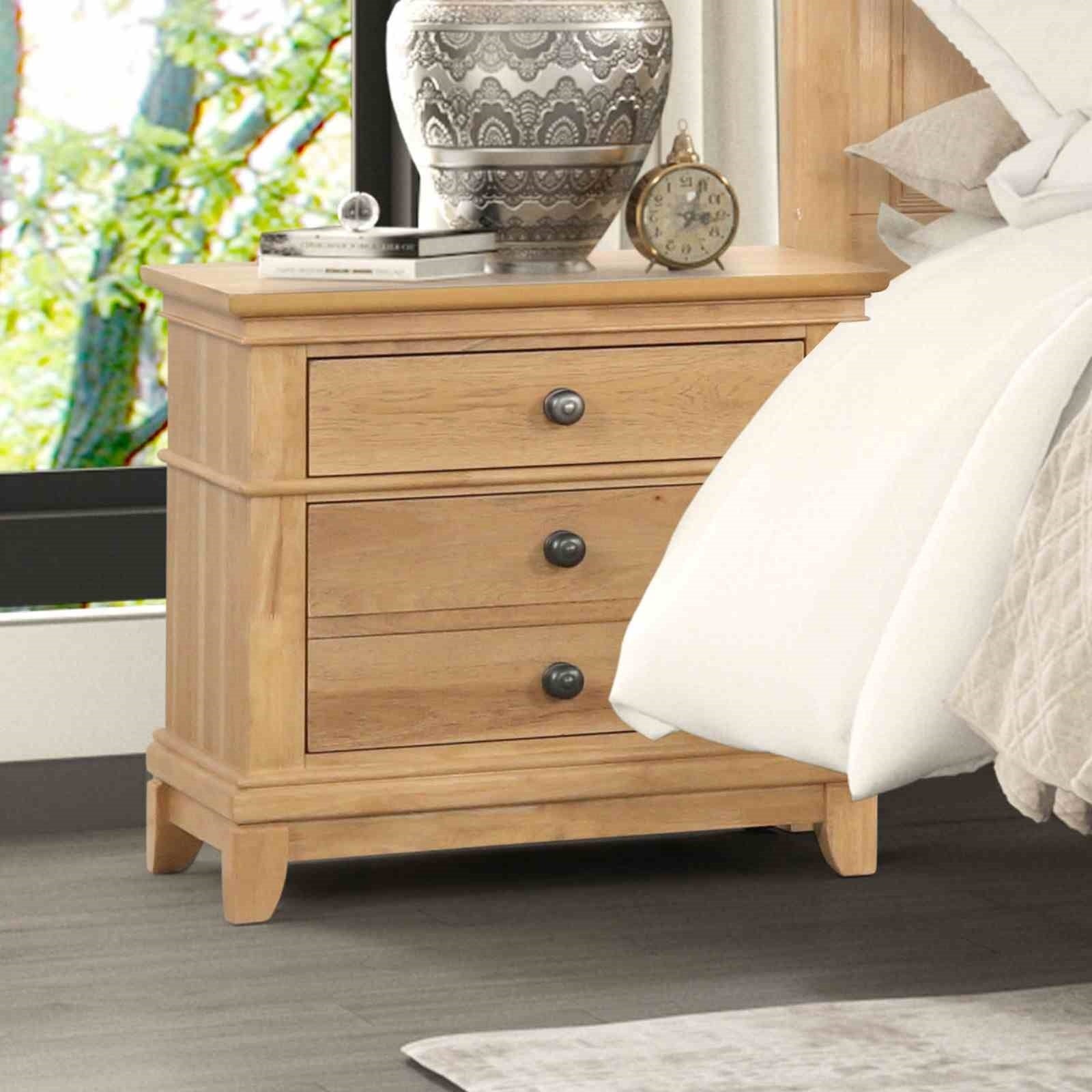 Farmhouse Oak Nightstand beside bed in modern farmhouse bedroom. 3-drawer wood nightstand with rustic charm and easy assembly.