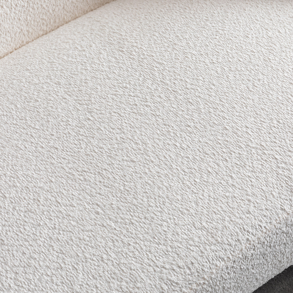 Close-up of plush textured upholstery on minimalist white curved sofa, showcasing soft and durable fabric.