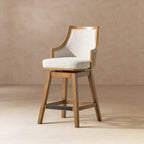 Rattan Swivel Counter Stool with Cane Back featuring a high back, recessed arms, and neutral gray upholstery, ideal for modern dining spaces.