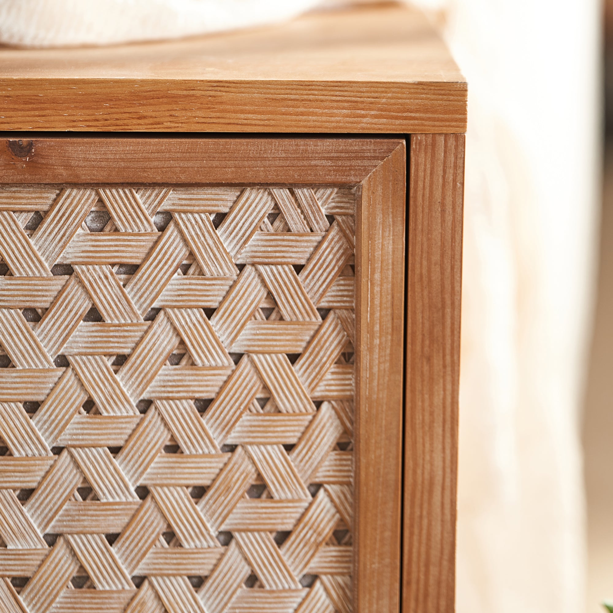 Corner view of the Rattan TV Stand Mid Century with Storage, highlighting the intricate boho woven door pattern.
