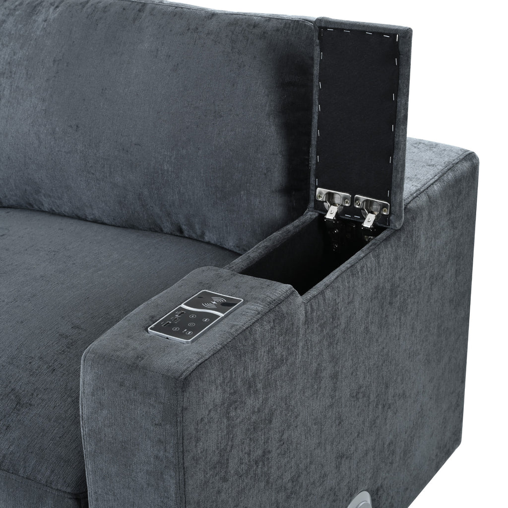 Close-up of modular sofa armrest with hidden storage compartment and control panel for USB, wireless charging, and Bluetooth speaker.