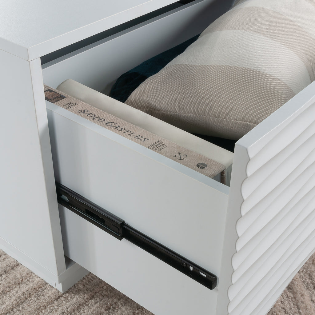Interior drawer view of the white coffee table showing ample storage space for books and cushions in a modern coastal design.