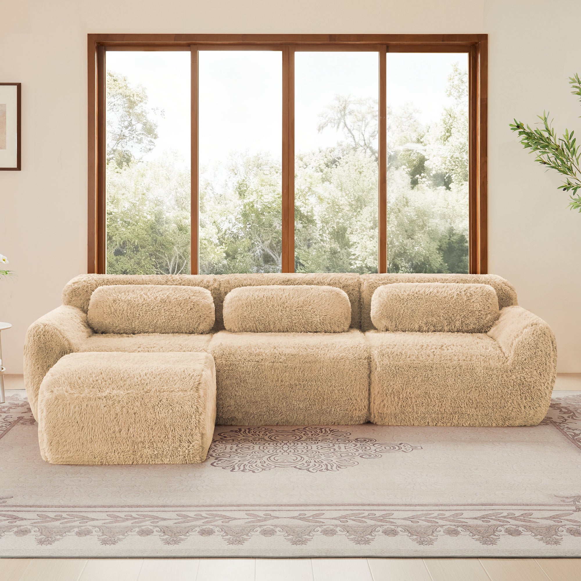Versatile beige modular sectional sofa with plush fabric and ottoman, ideal for spacious interiors with large windows.