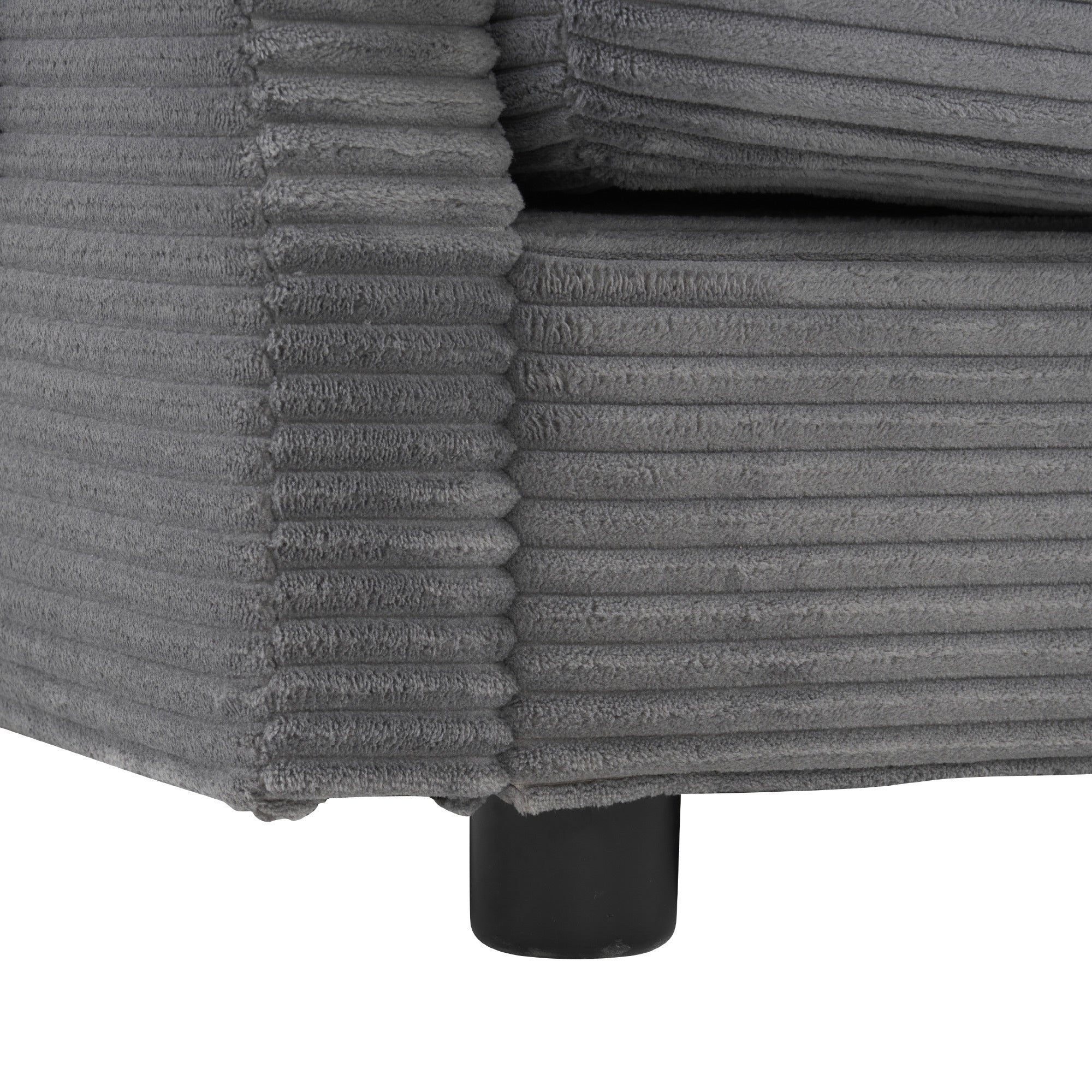 Corner detail of modular sofa base with ribbed corduroy fabric and black leg support for a sturdy, modern design.