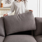 Close-up of person lifting back cushion from modular sofa, showing removable cushions for easy cleaning and maintenance.