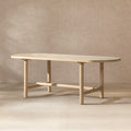Oval dining table in light natural cerused reclaimed pine with four cylindrical legs and a central support beam.