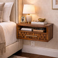 Floating dark wood bedside table with a textured drawer front, open shelf, and sleek gold handle beside a beige bed.