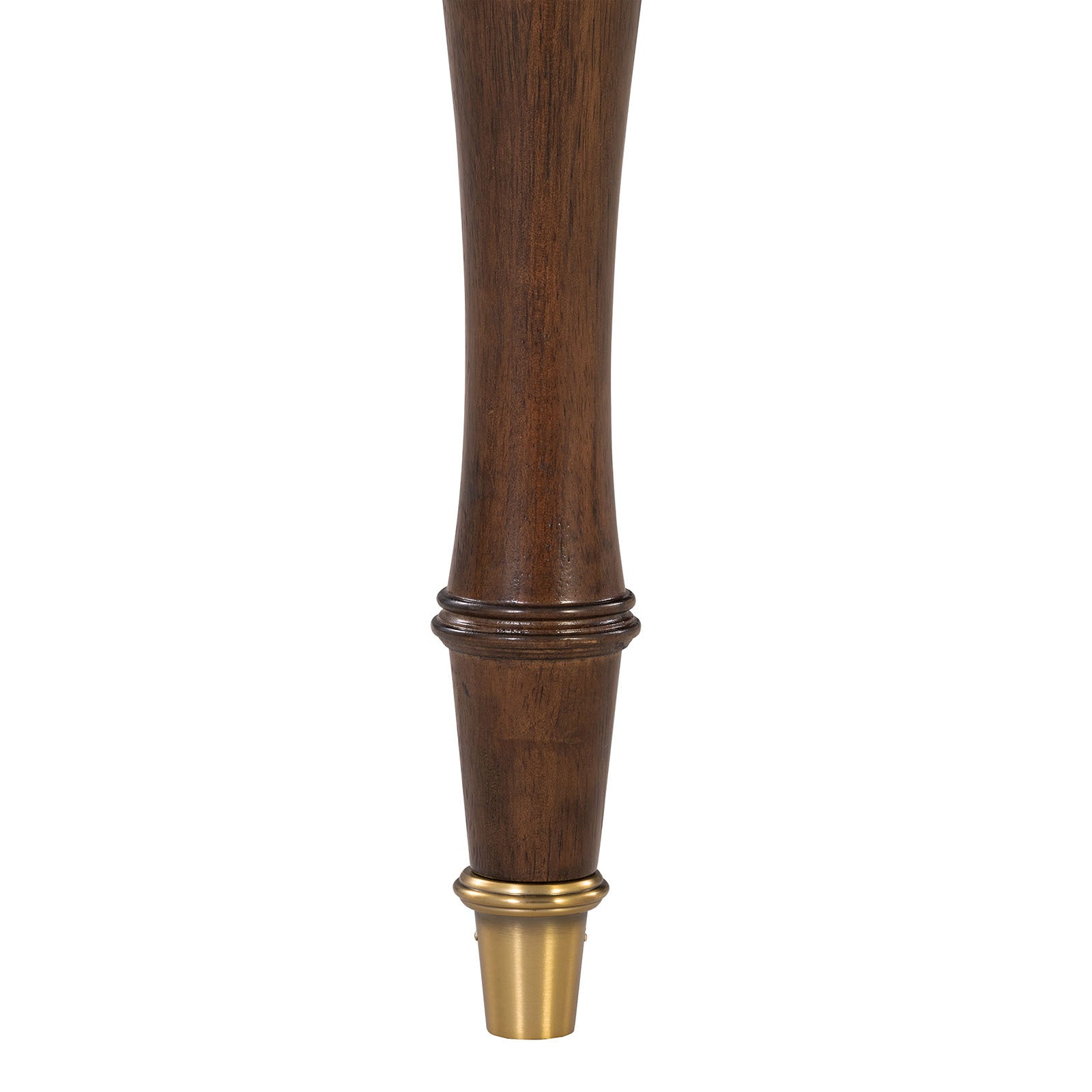 Close-up of solid wood dining chair leg with elegant gold-capped foot, showcasing craftsmanship and transitional design detail.