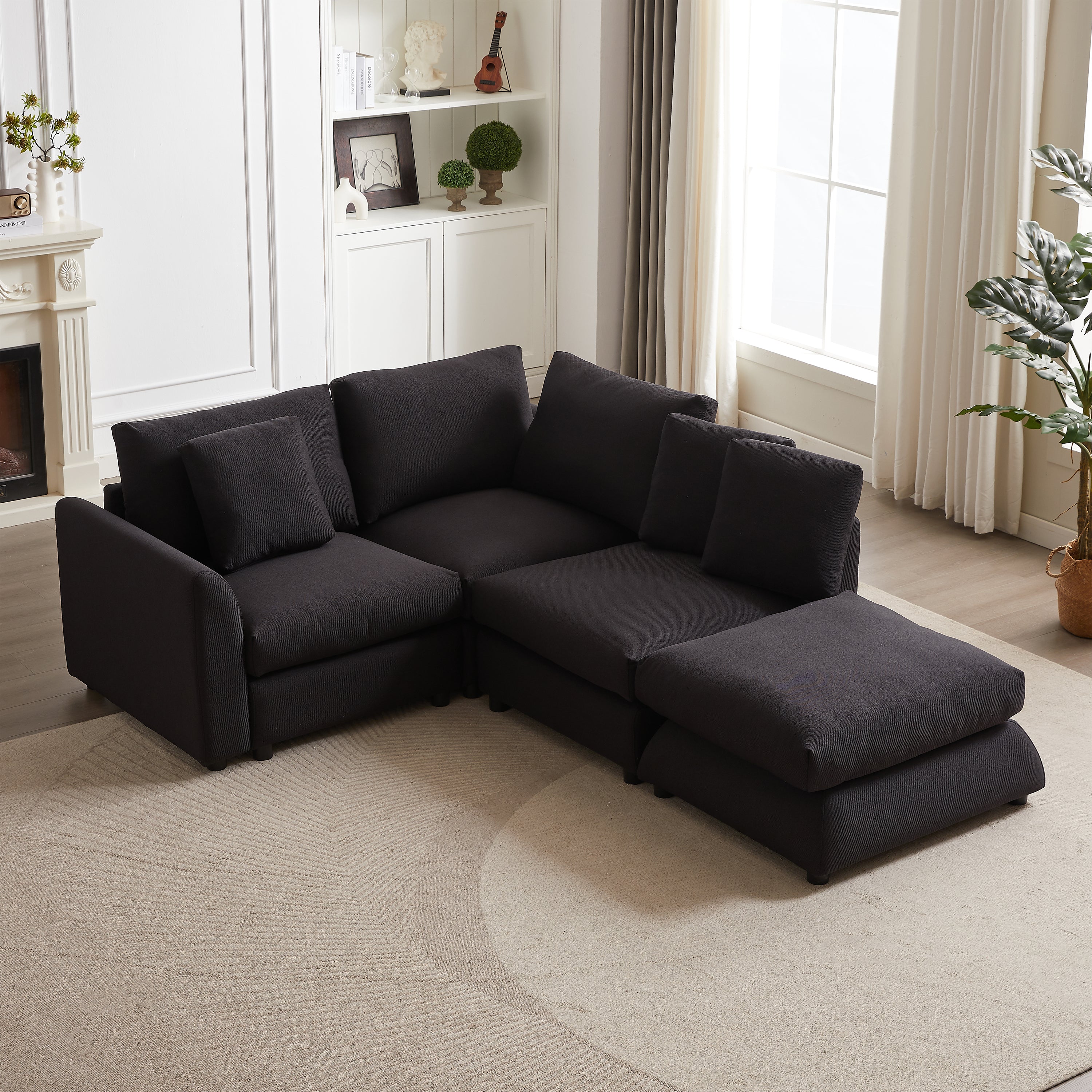 Corner view of modular L-shaped sofa with ottoman, showcasing plush cushions and pillows in a bright, elegant living space.