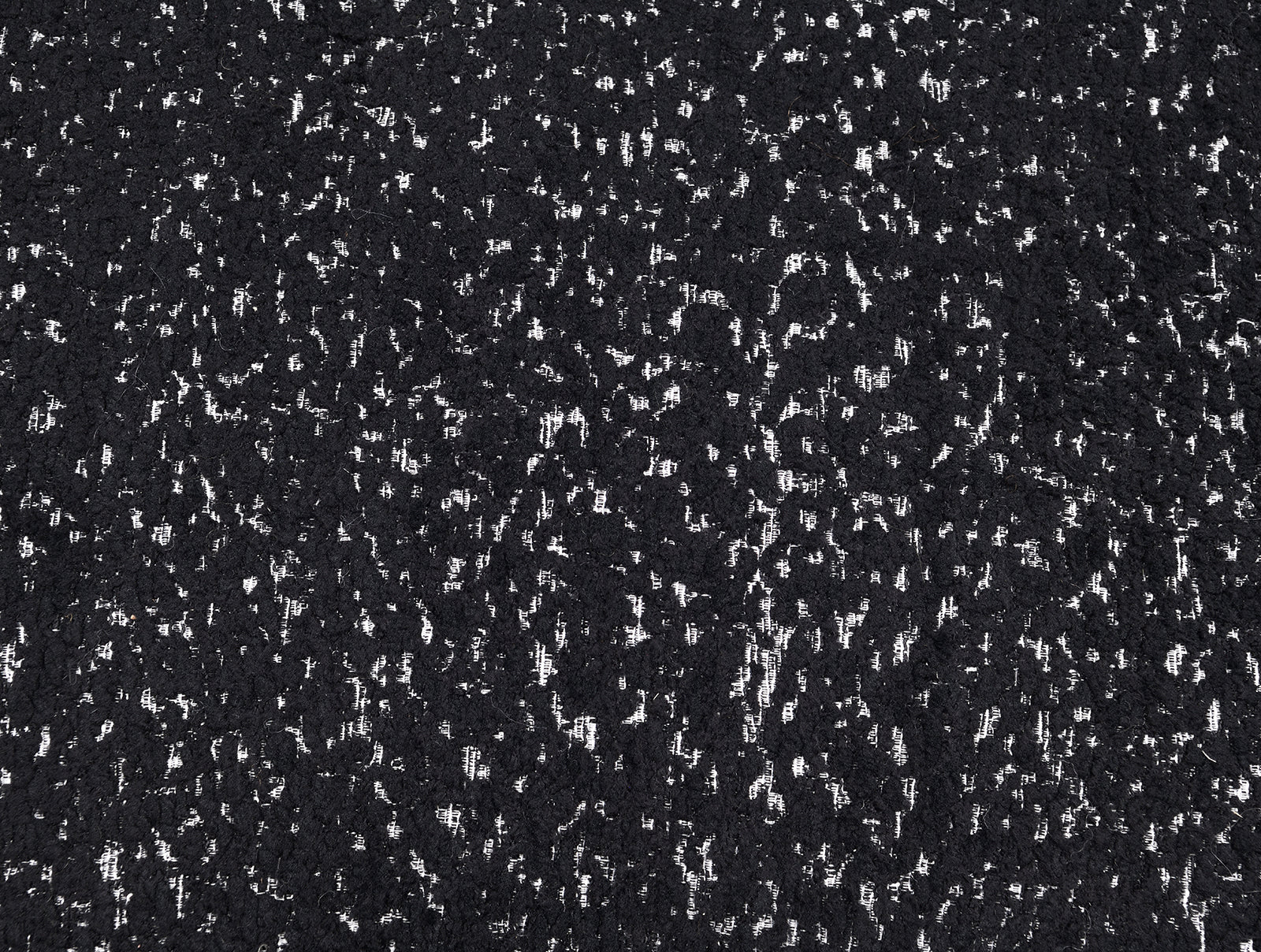 Close-up of black boucle fabric texture on swivel chair. Durable and stylish upholstery enhances the chair’s contemporary appeal.