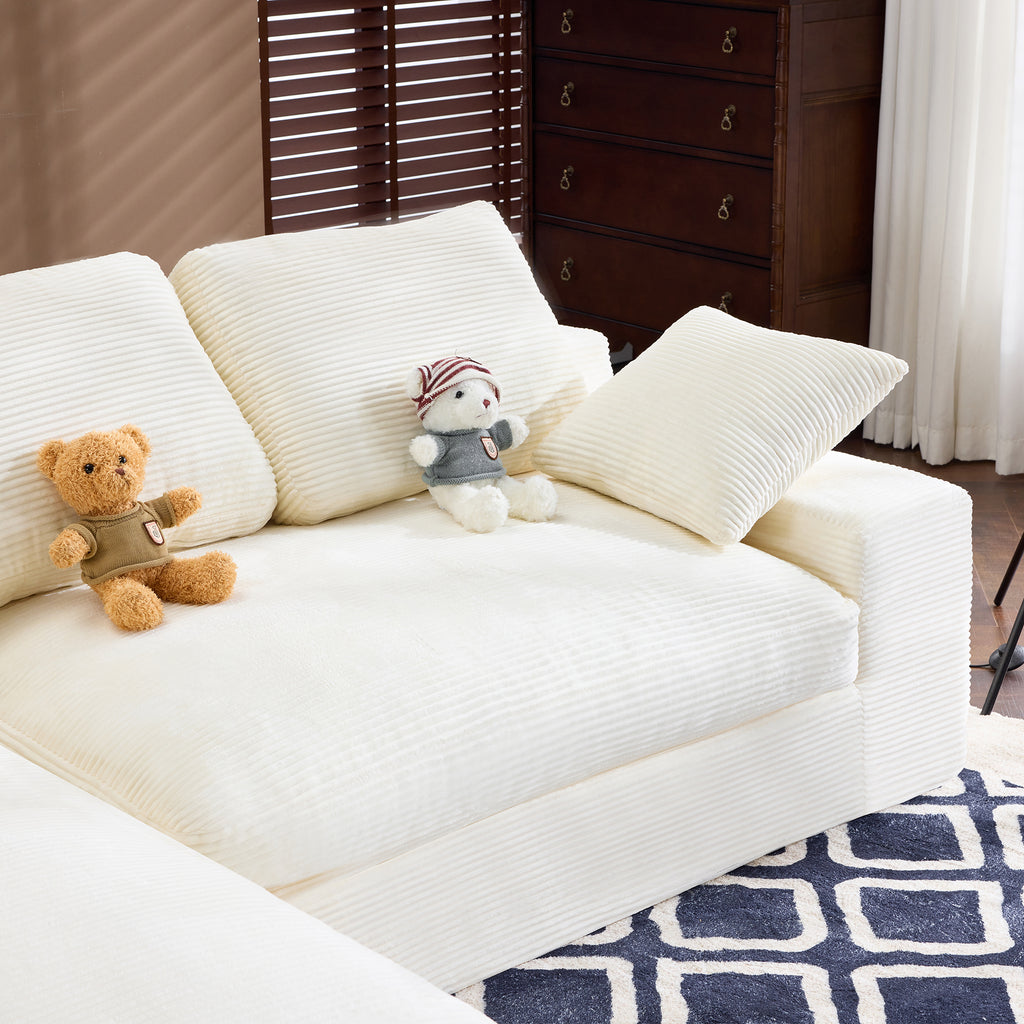 Right side of White Corduroy Sofa with 2 pillows and 3 back cushions, styled with plush toys and soft seating.