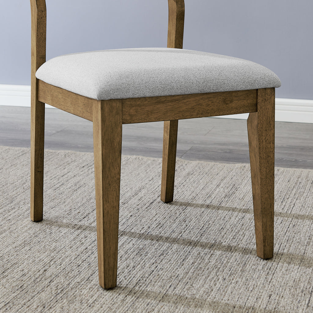 Detail of Walnut Oak dining chair leg and cushioned seat, showing durable wood frame and soft fabric for comfort and style in dining areas.