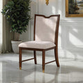 Transitional dining chair with upholstered seat and backrest, solid wood frame, and gold-capped legs in a classic interior setting.