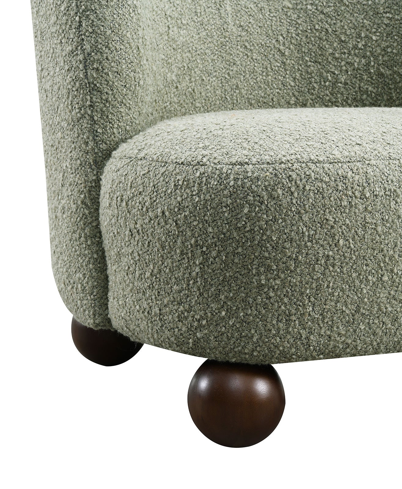 Detail of green boucle chair seat and dark wood ball feet. Durable and stylish base enhances modern interior aesthetics.