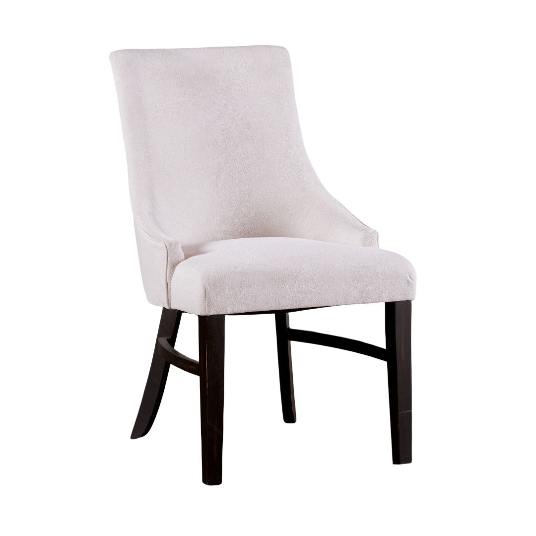 Beige padded wingback dining arm chair with curved backrest and black frame, perfect for transitional dining room decor.