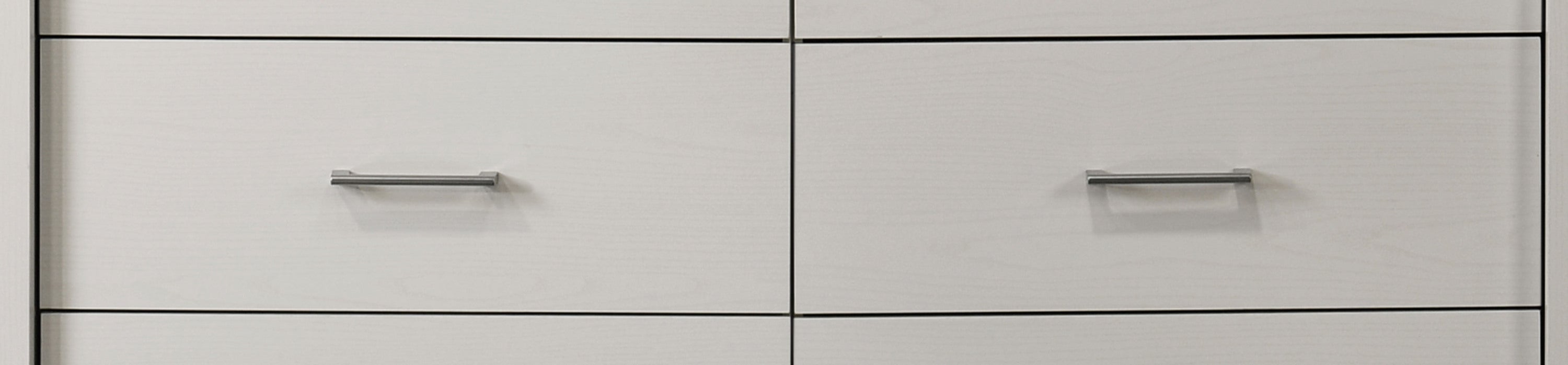 Middle drawer section of white 6-drawer dresser with silver handles. Offers ample storage and a clean, modern aesthetic.