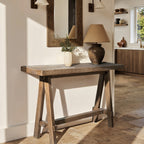 Medium-brown reclaimed elm trestle console table with rustic, weathered wood grain in a classic entryway setting.