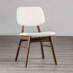 Mid-century dining chair with angled walnut legs and padded beige seat, ideal for modern dining room comfort and style.