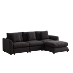 Angled view of modular L-shaped sofa with ottoman, 3 cushions, and 4 pillows in dark upholstery, designed for comfort and modern interiors.