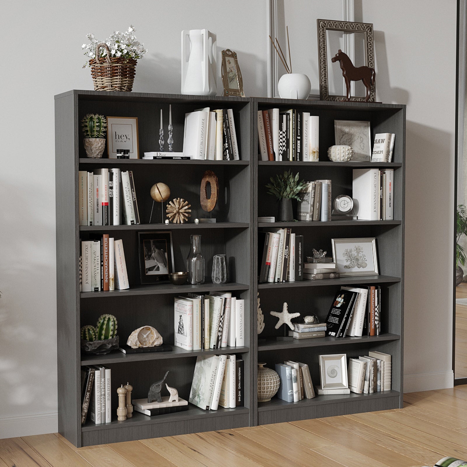 Two grey 5-tier bookshelves in a living room setting, showcasing spacious storage for books, decor, and manga collections.