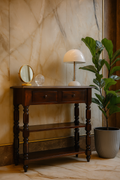 Wooden side table with decorative items against a marble wall