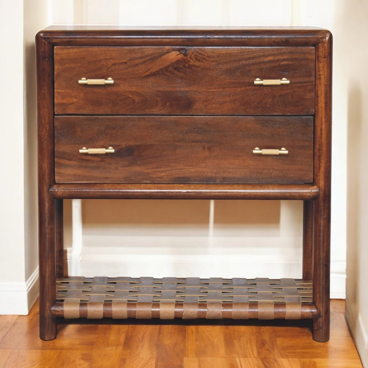 Wooden dresser with three drawers and a woven shelf on a wooden floor.