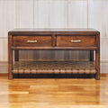 Wooden console table with two drawers and a woven shelf on a wooden floor.