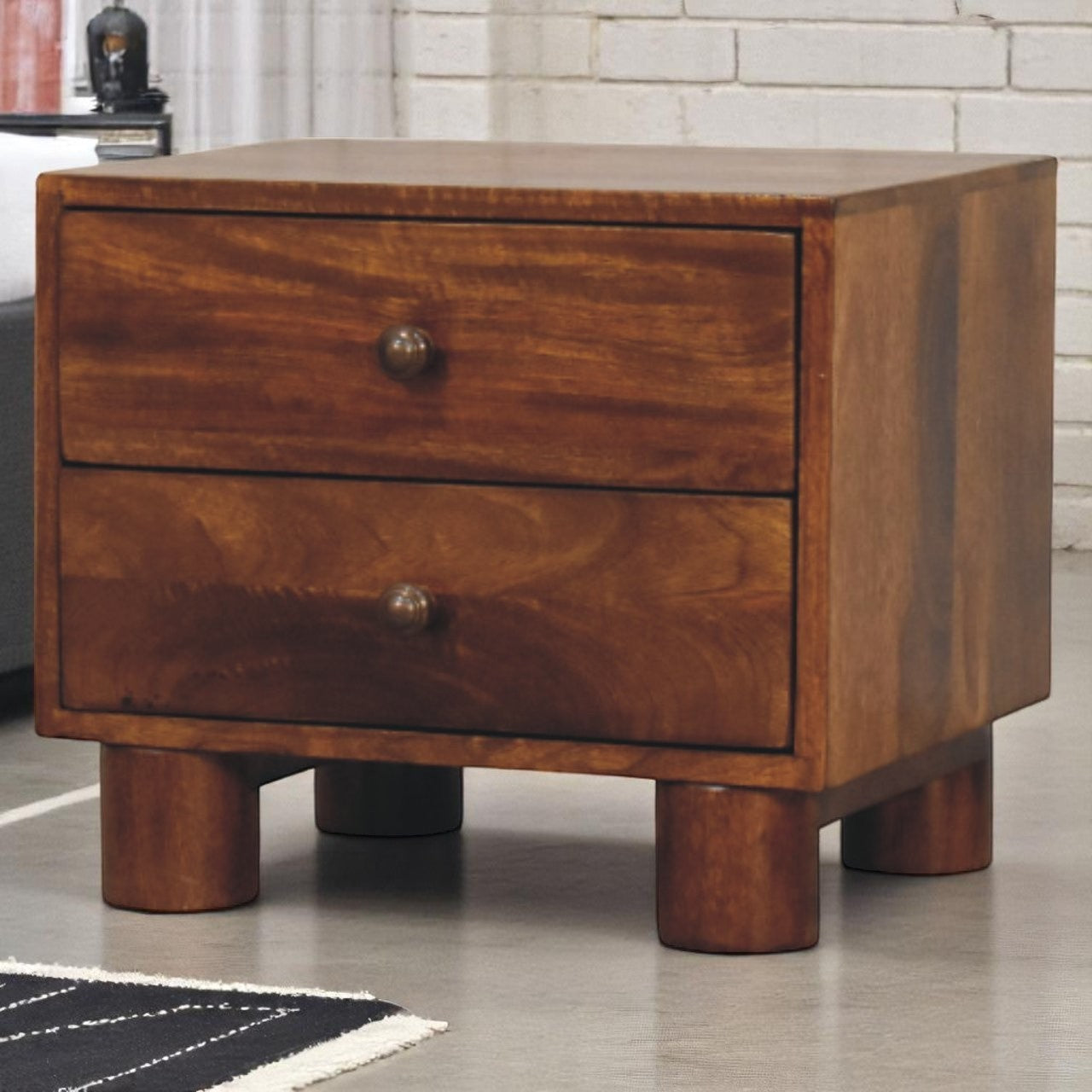 Wooden nightstand with two drawers on a tiled floor.