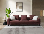 Maroon sofa with white cushions in a modern living room setting.