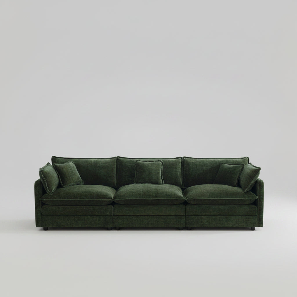 Green sofa in a living room with large windows and neutral decor