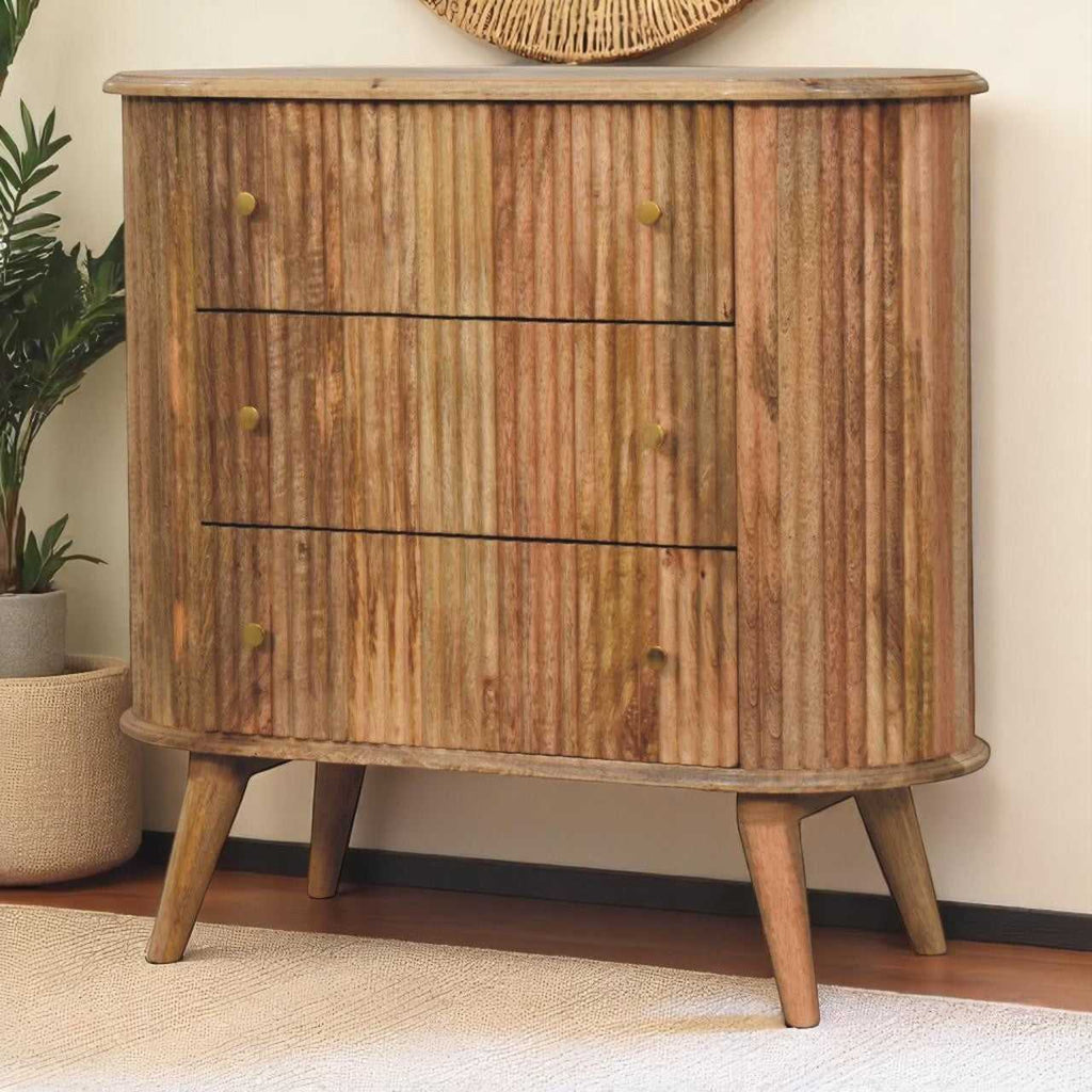 Wooden dresser with three drawers in a room setting with a plant and rug.