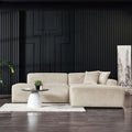 Cream corduroy right-facing sectional sofa with a modern, low-profile design set against a black paneled wall.