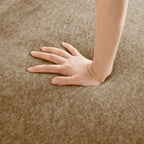 Hand pressing into seat cushion of Velvet L Shape Modular Sectional Sofa. Showcases plush, supportive foam and soft velvet.