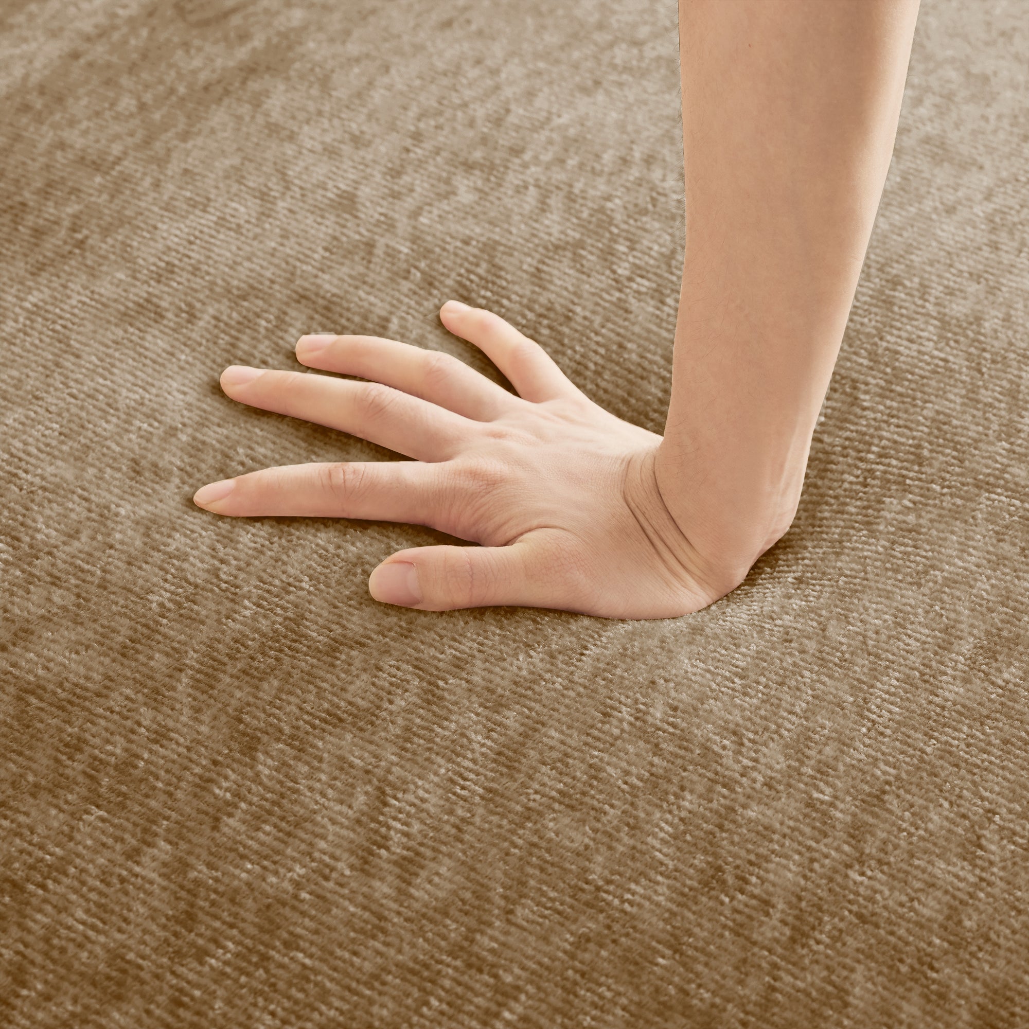 Hand pressing into seat cushion of Velvet L Shape Modular Sectional Sofa. Showcases plush, supportive foam and soft velvet.