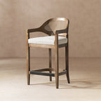 Mid-Century Stool - Cane Back Modern with oak frame, curved arms, and brass footrest. Features a woven wicker back and cushioned seat.