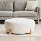 Modish Round Ottoman with Boucle Top and Natural Wood Legs.